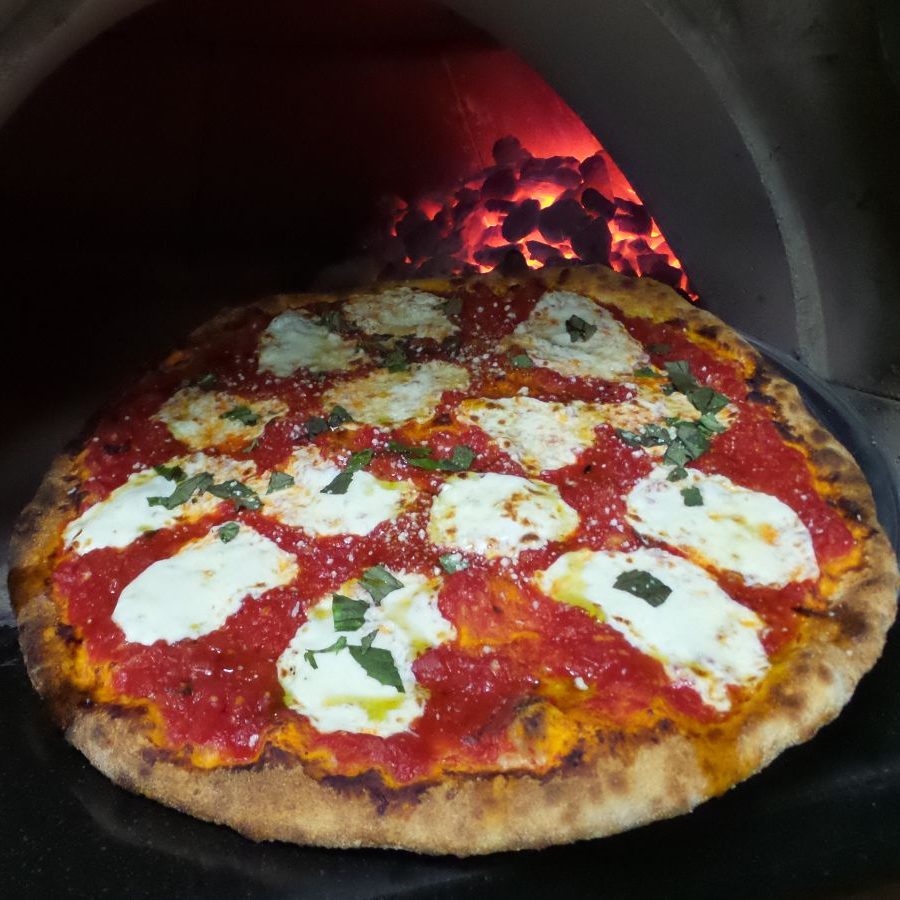 A pizza in a wood fired oven.
